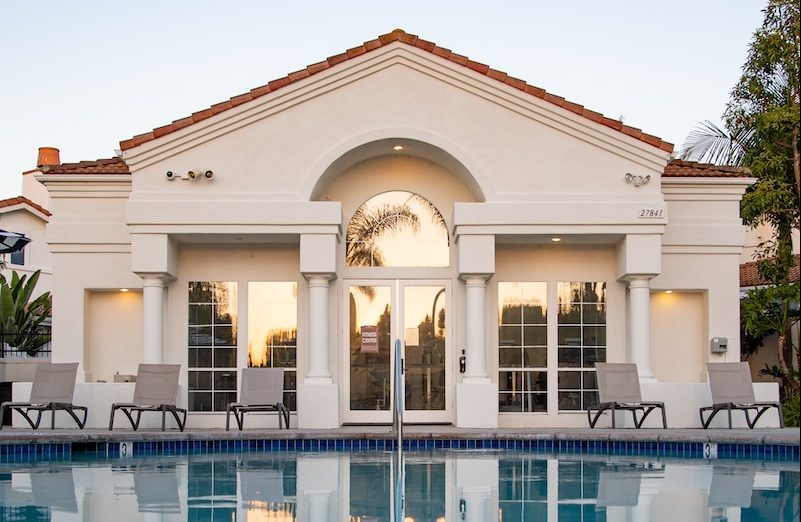 white and brown concrete building near swimming pool during daytime